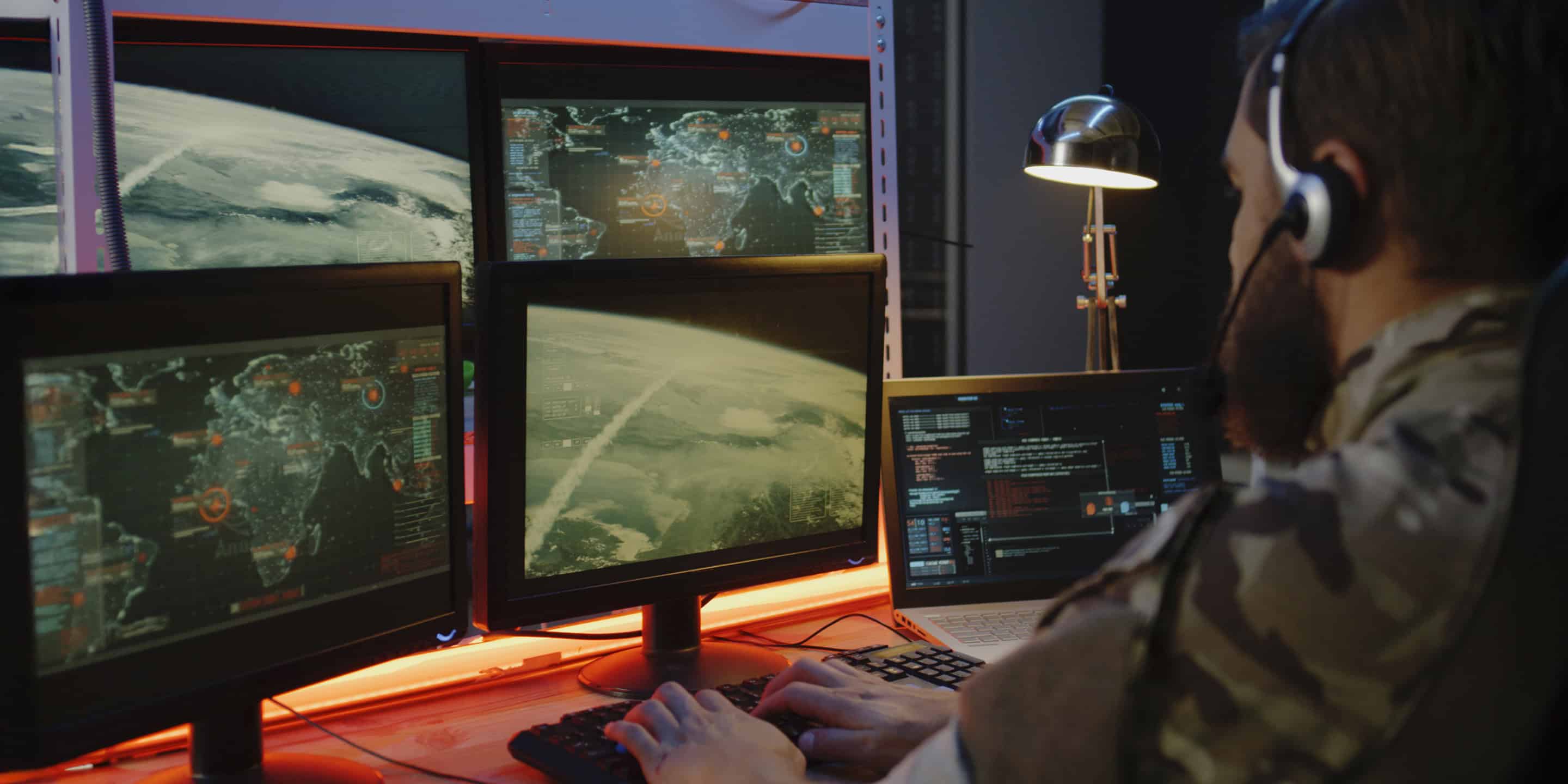 Analyst monitoring Earth from space on screens in a space operations center